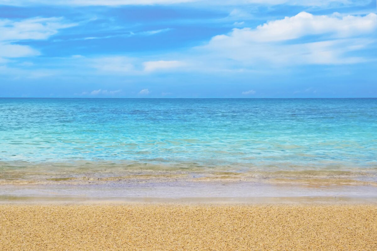 sandy beach with clear water and blue sky